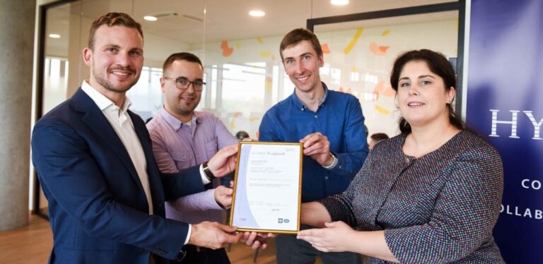 Hyarchis-medewerkers tonen ISO 27001-certificaat.