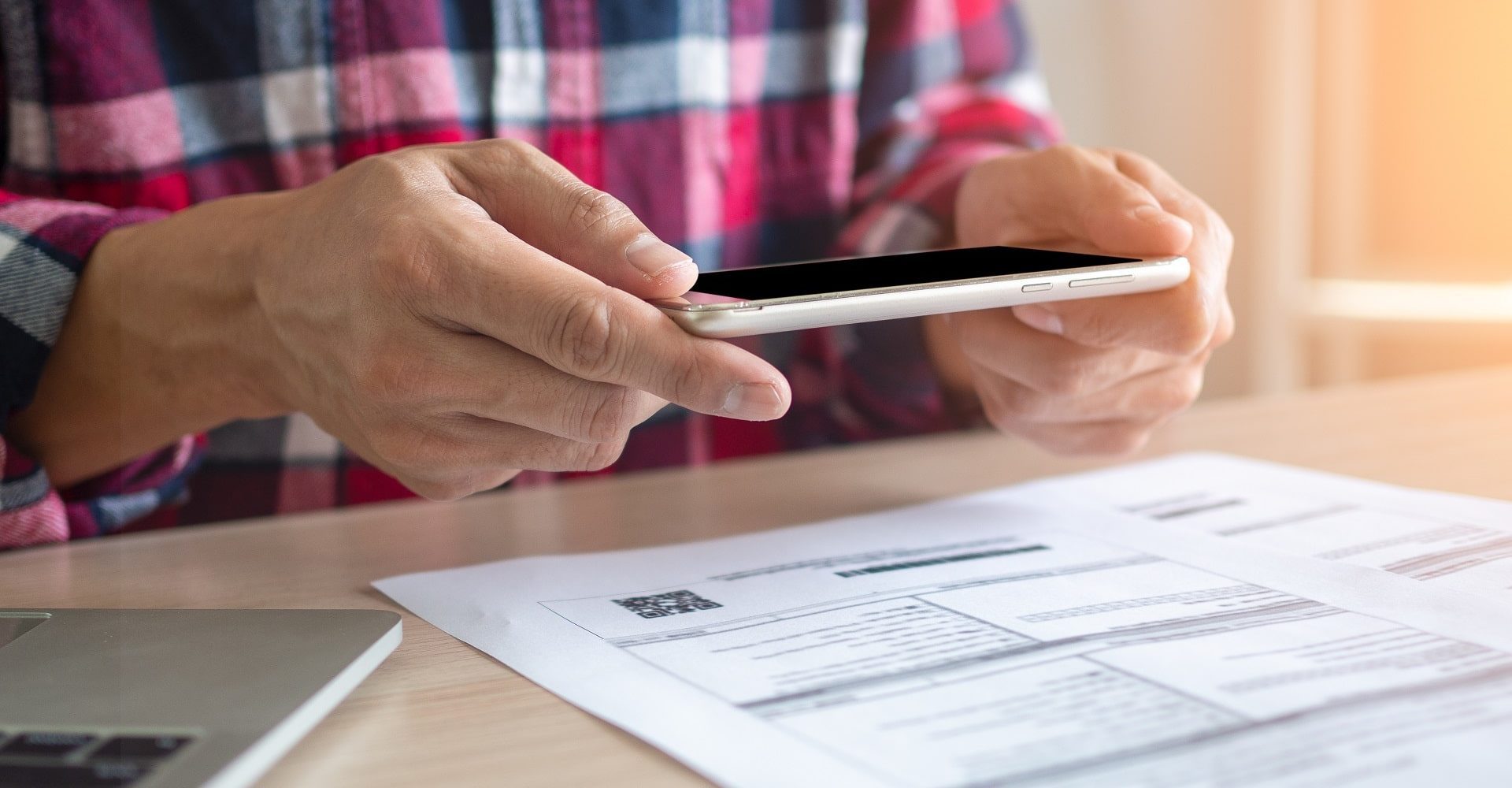 Een persoon gebruikt de OCR app om de rekeningen te betalen.